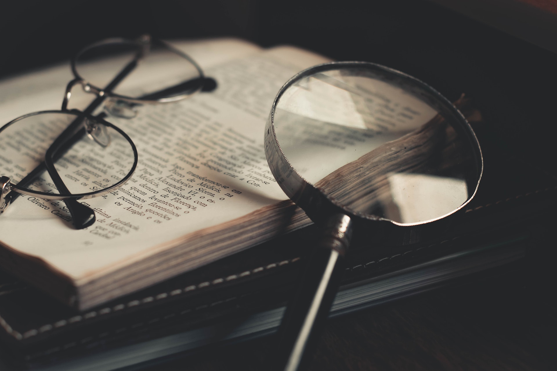 magnifying glass with glasses on dictionary